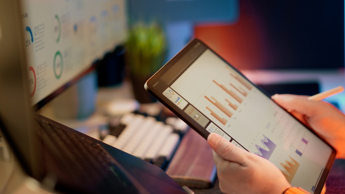 A modern workspace with a monitor displaying a financial dashboard for multi-chain stablecoin payments