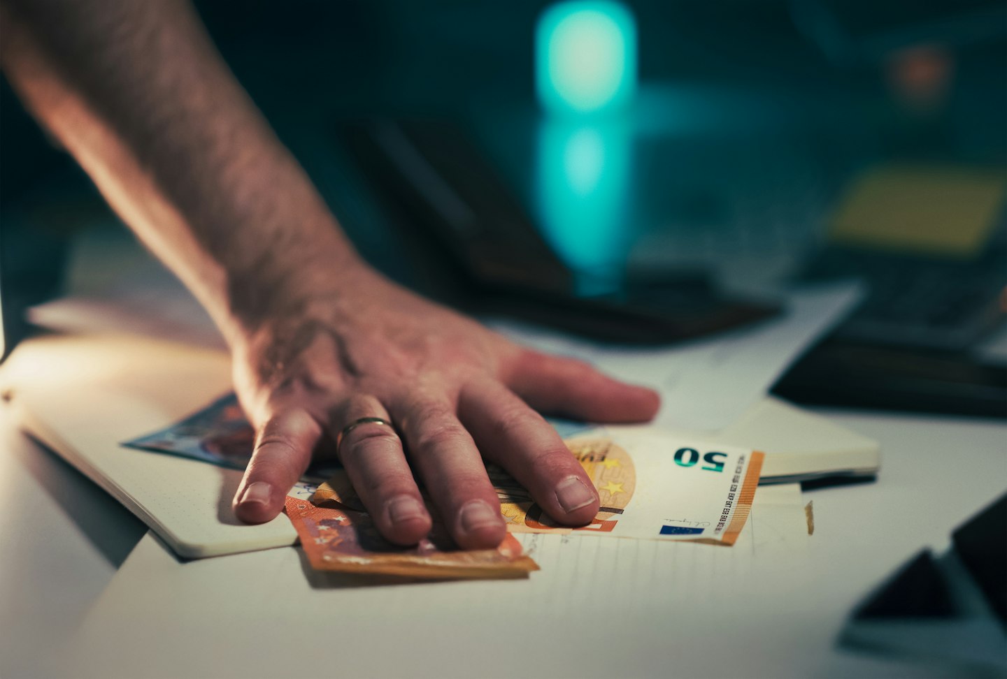 Hand reaching for euro banknotes on a table