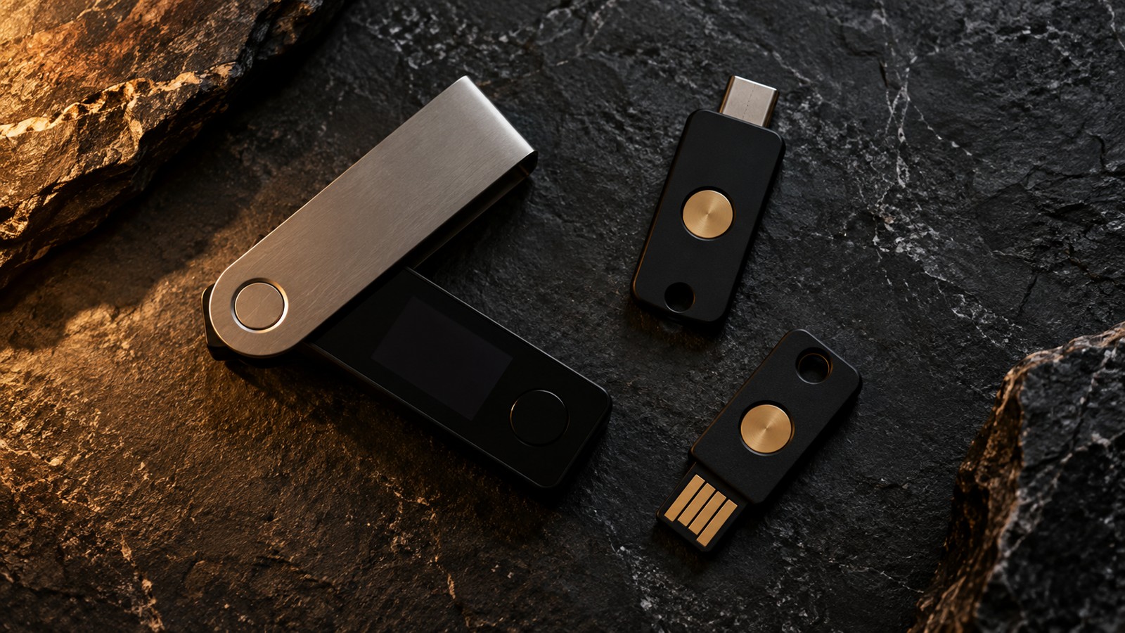 A hardware wallet and security keys on a dark stone surface